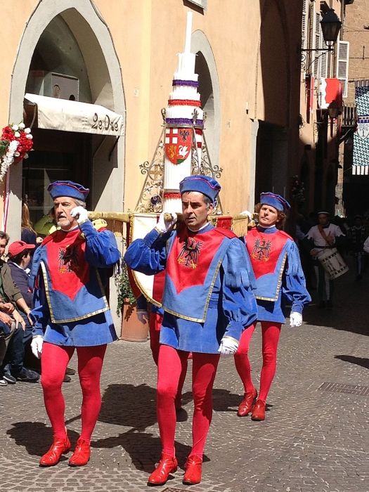 Men carrying holy candles and representing one of the quarters