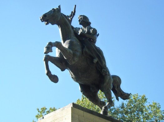 Anita, on horseback, carrying her baby and brandishing a gun
